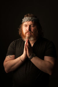 Portrait of man wearing hat against black background