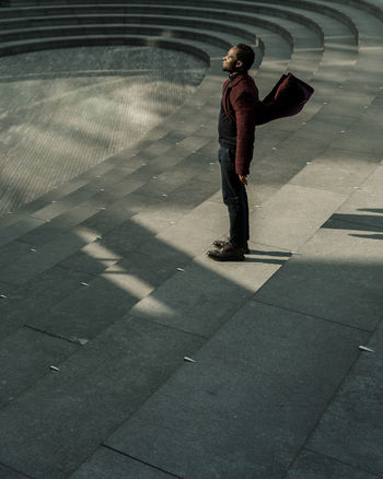 FULL LENGTH OF A MAN WALKING ON FOOTPATH