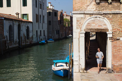 Full length of man walking on archway by canal