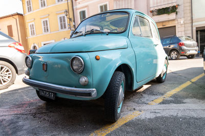 Vintage car on street against buildings in city