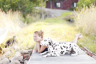 Woman with dalmatian dog at jetty