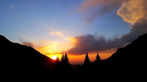 Scenic view of silhouette mountains against sky at sunset