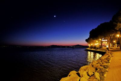 Scenic view of lake against sky at night