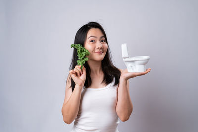 Portrait of a smiling young woman against white background