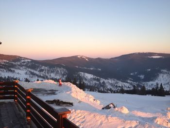 Scenic view of snowcapped mountains against clear sky during sunset