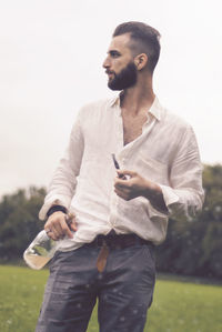 Full length of young man smoking against sky