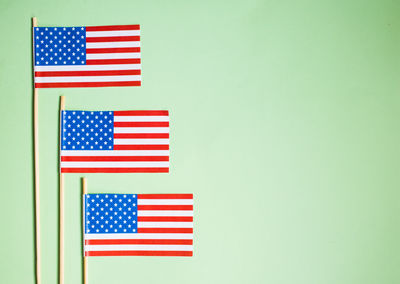 Close-up of small american flags over colored background