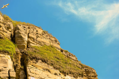 Low angle view of cliff against sky