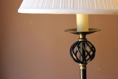 Close-up of lamp shade against coral wall