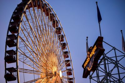 Low angle view of ferris wheel against blue sky