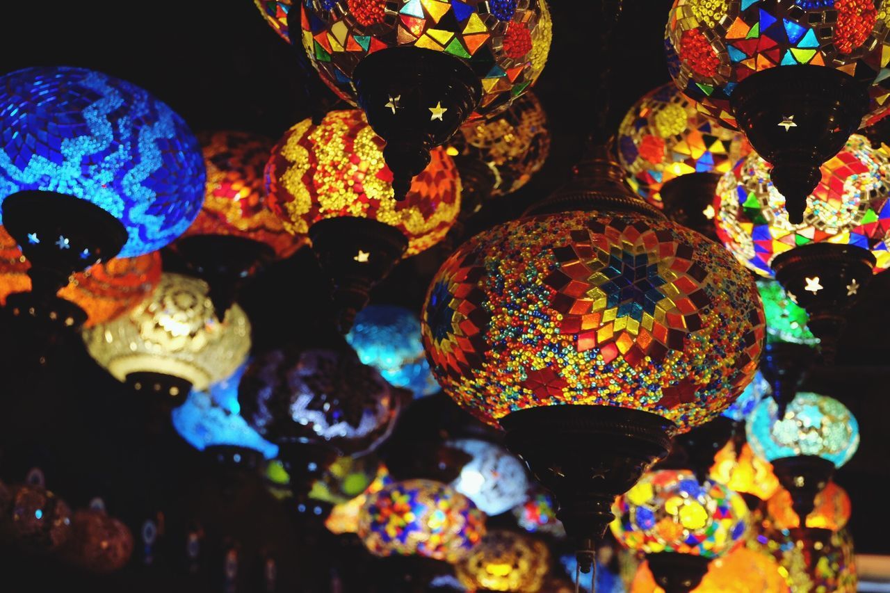 LOW ANGLE VIEW OF ILLUMINATED LANTERNS HANGING ON WALL