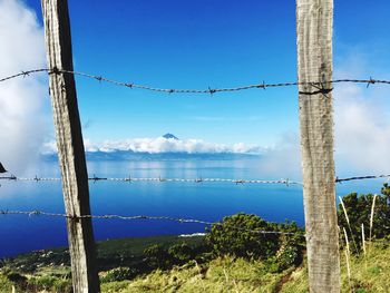 View of barbed wire fence against blue sky