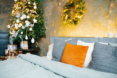 Romantic bedroom in light blue tones with garlands of lights decorated to celebrate the new year