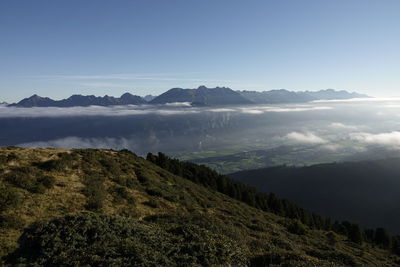 Blur sky, yellow mountain grass, green fields in the valley