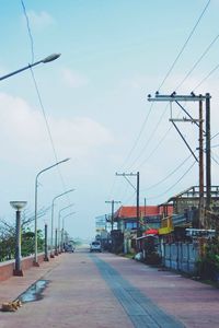 Electricity pylon against cloudy sky