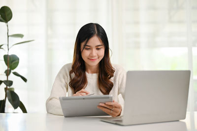 Young woman using laptop at home