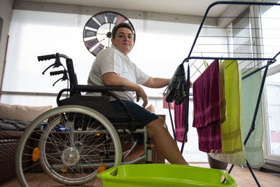 A disabled person on a wheelchair washes laundry