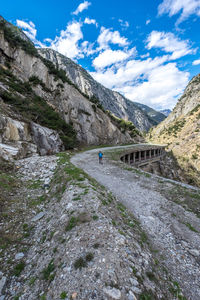 Scenic view of road by mountains against sky