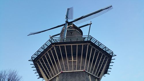Low angle view of traditional windmill against clear blue sky