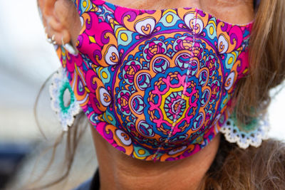 Close-up of woman wearing colorful face mask
