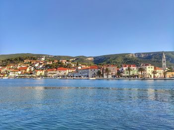 Town by sea against clear sky