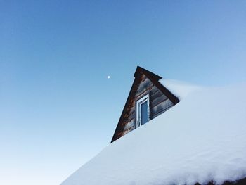 Low angle view of snow covered house against sky 