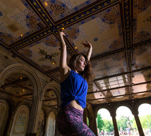 Low angle view of woman standing against ceiling