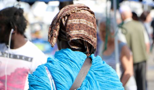Rear view of woman covering head with scarf in city