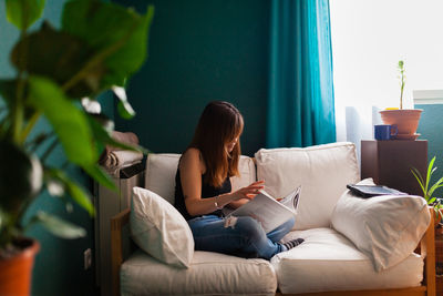 Woman sitting on sofa at home