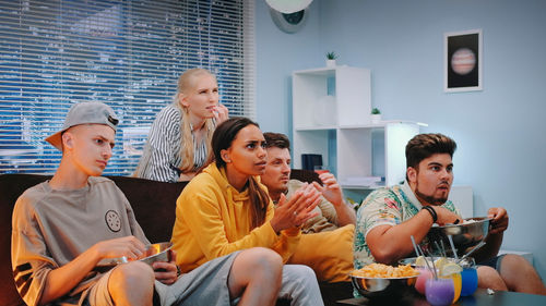 Female friends using mobile phone while sitting at home