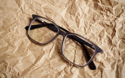 Close-up of eyeglasses on crumpled brown paper