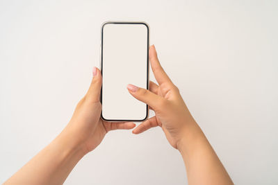 Midsection of person holding smart phone against white background