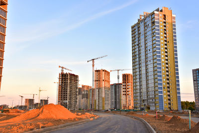 View on the large construction site with tower cranes and buildings on sunset 