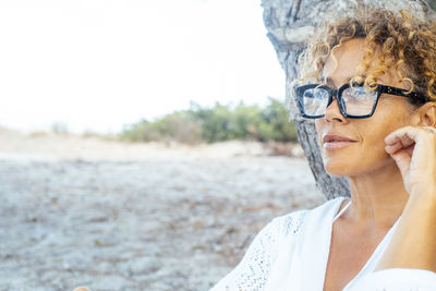 Young woman wearing sunglasses while standing outdoors