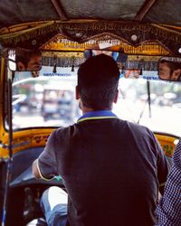 Rear view of man driving rickshaw