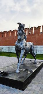 Statue by fountain against sky