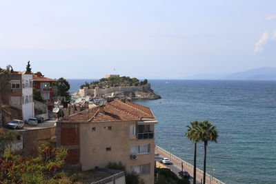 High angle view of buildings by sea against sky