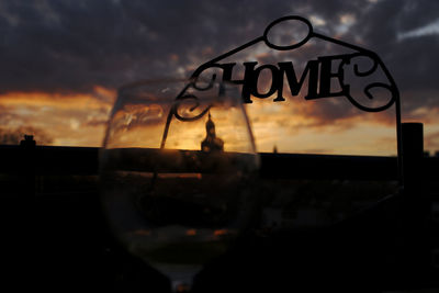 Close-up of wine glass against sunset sky