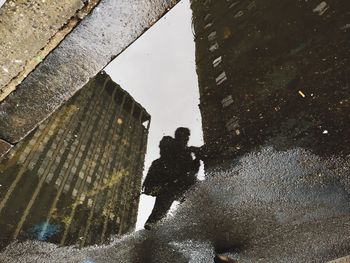 Reflection of people in puddle