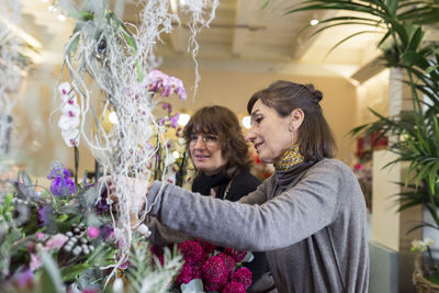 Two woman at flower shop arranging some flowers