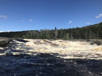 Scenic view of waterfall against sky