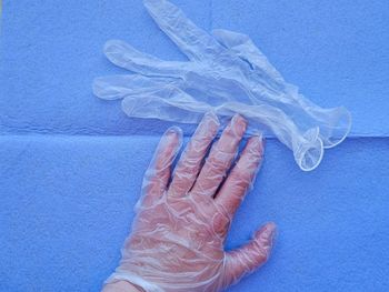 High angle view of human hand against blue background