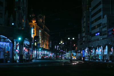 Illuminated city street and buildings at night