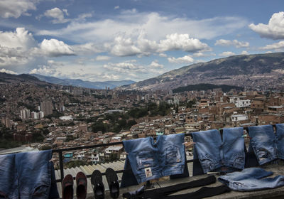 High angle view of jeans drying on clothesline against cityscape