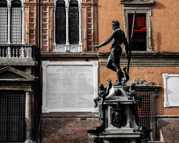 Statue against building in city