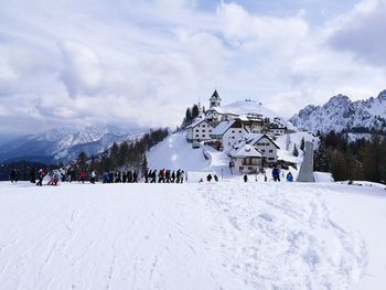 People on snowcapped mountain against sky