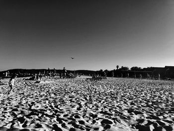 People on beach against clear sky