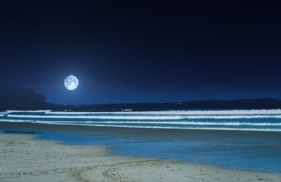 Scenic view of sea against clear sky at night