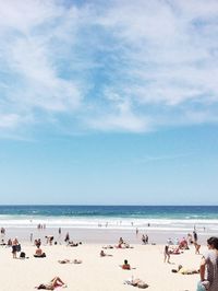 People at beach against blue sky