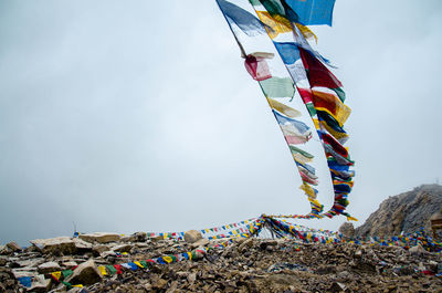 Low angle view of flags hanging against sky